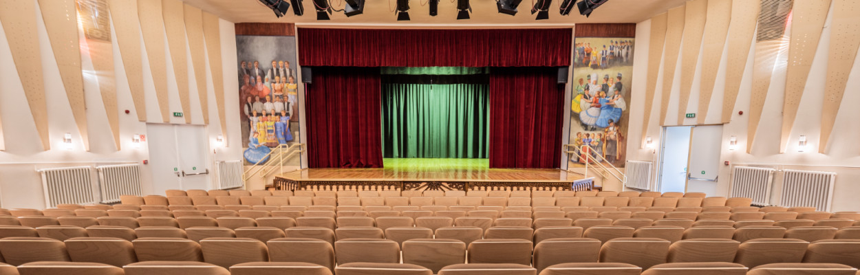 Színházi színpad látképe széksorok közül