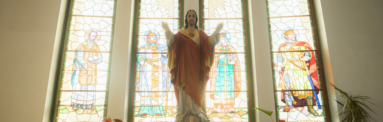 Jézus szobra templomi díszes ablakok előtt